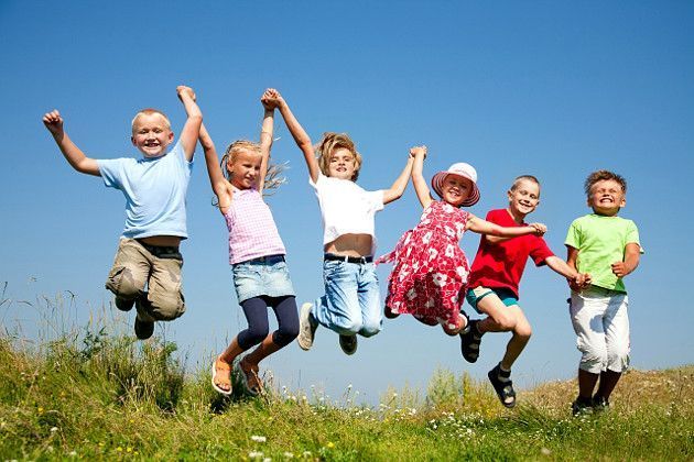 enfants se tenants la main dans un saut joyeux